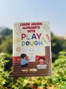 Book cover 'Learn Arabic Alphabets With Play Dough' depicting children drawing and playing, designed to help kids learn Arabic.